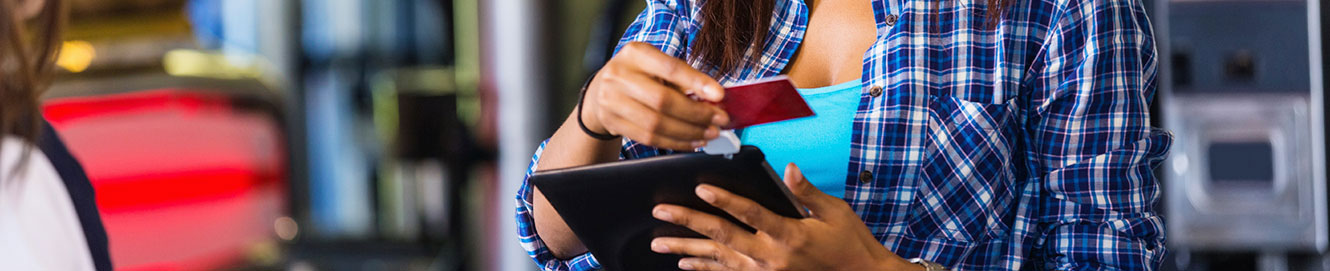 Woman taking credit card payment on tablet